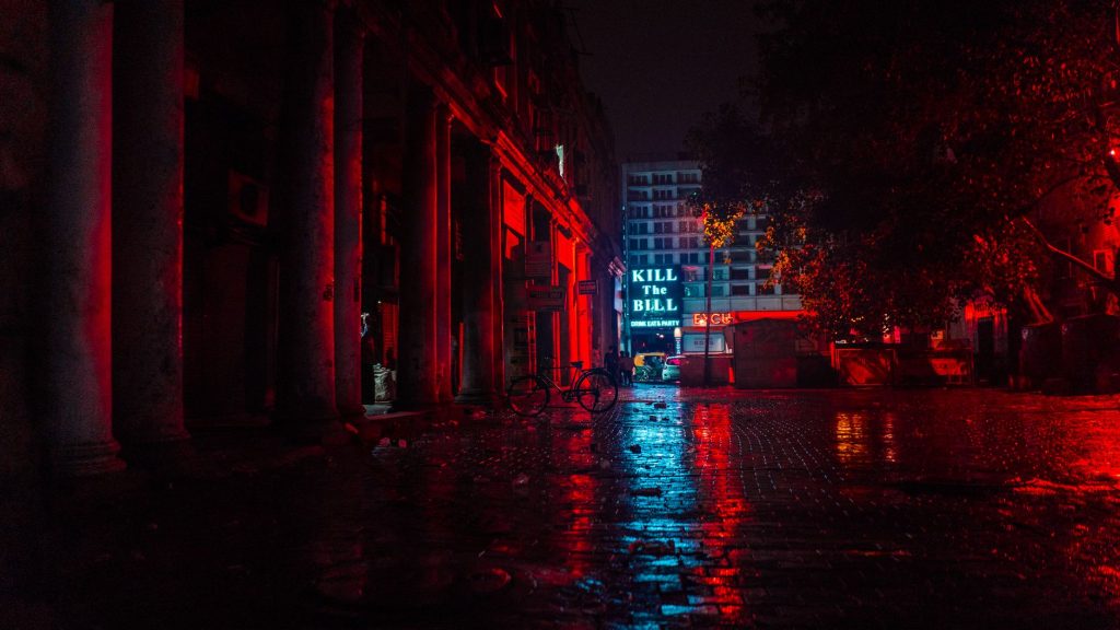 Rue de ville la nuit aux lumières néon, ambiance thriller d'espionnage urbain