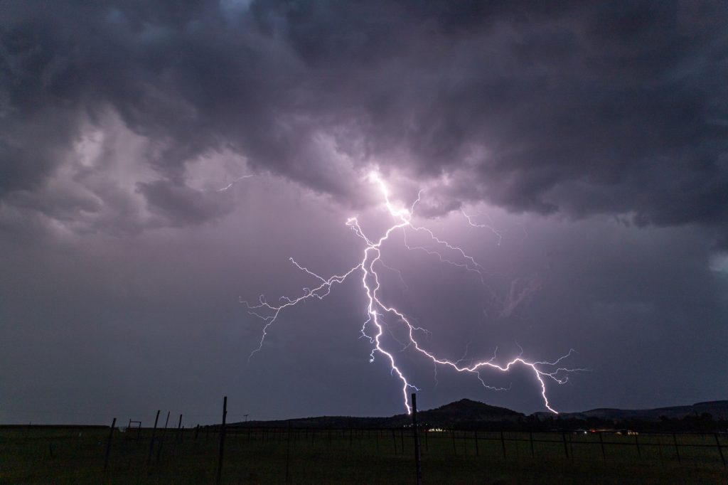 Éclair d’énergie verte fendant un ciel sombre, écho de la puissance psychique de la Tornade