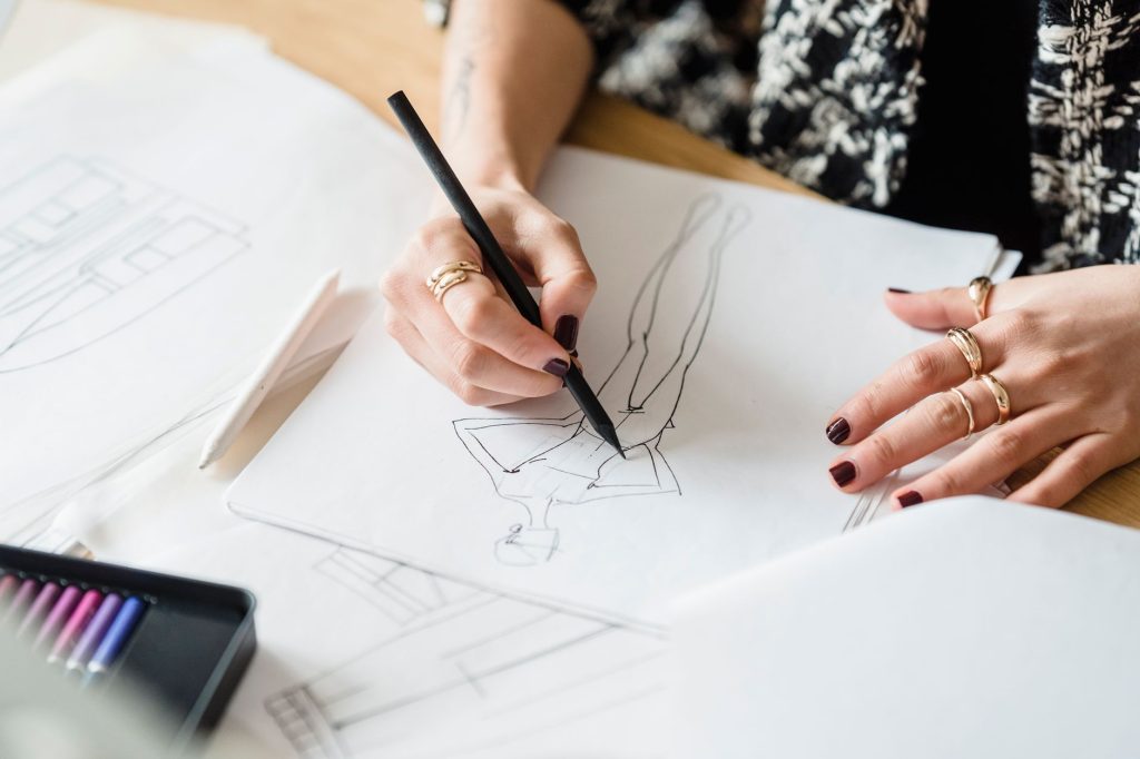 Illustrateur en train de dessiner sur un bureau couvert de croquis