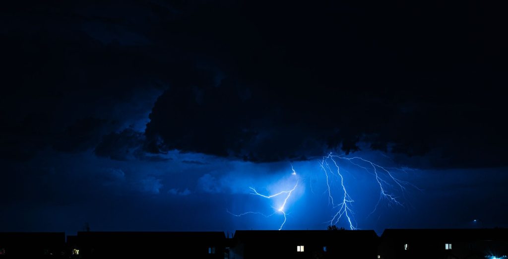Eclairs dechirant un ciel sombre au-dessus d un paysage devaste